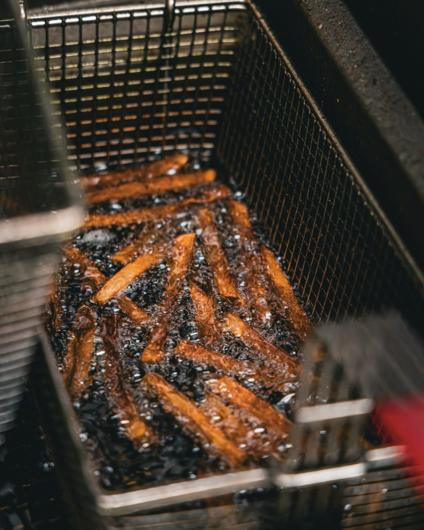 Seasoned fries cooking in the fryer basket